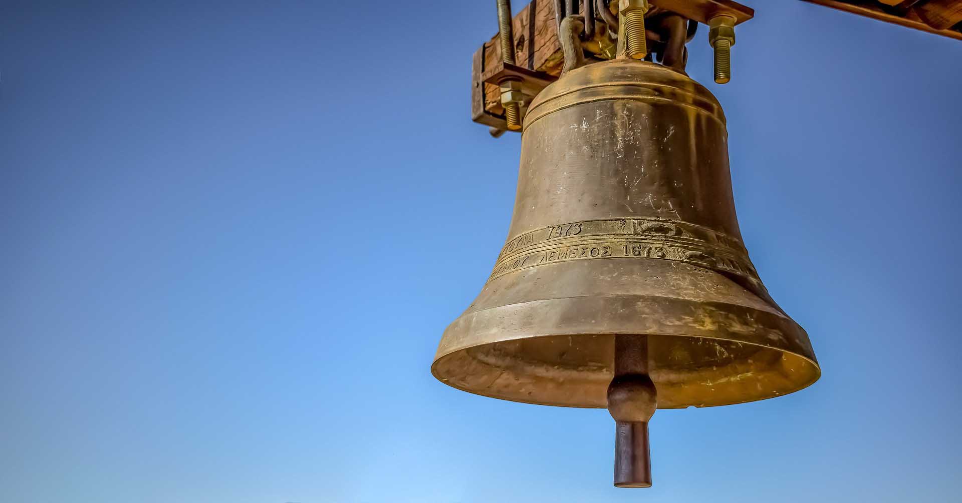 Large church bell against a clear blue sky