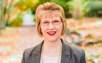 headshot of ellen johanson in front of fall trees and leaves