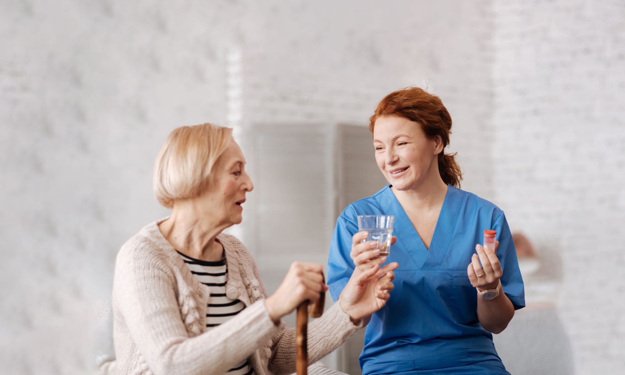 Health Care Giver giving medicine to senior resident